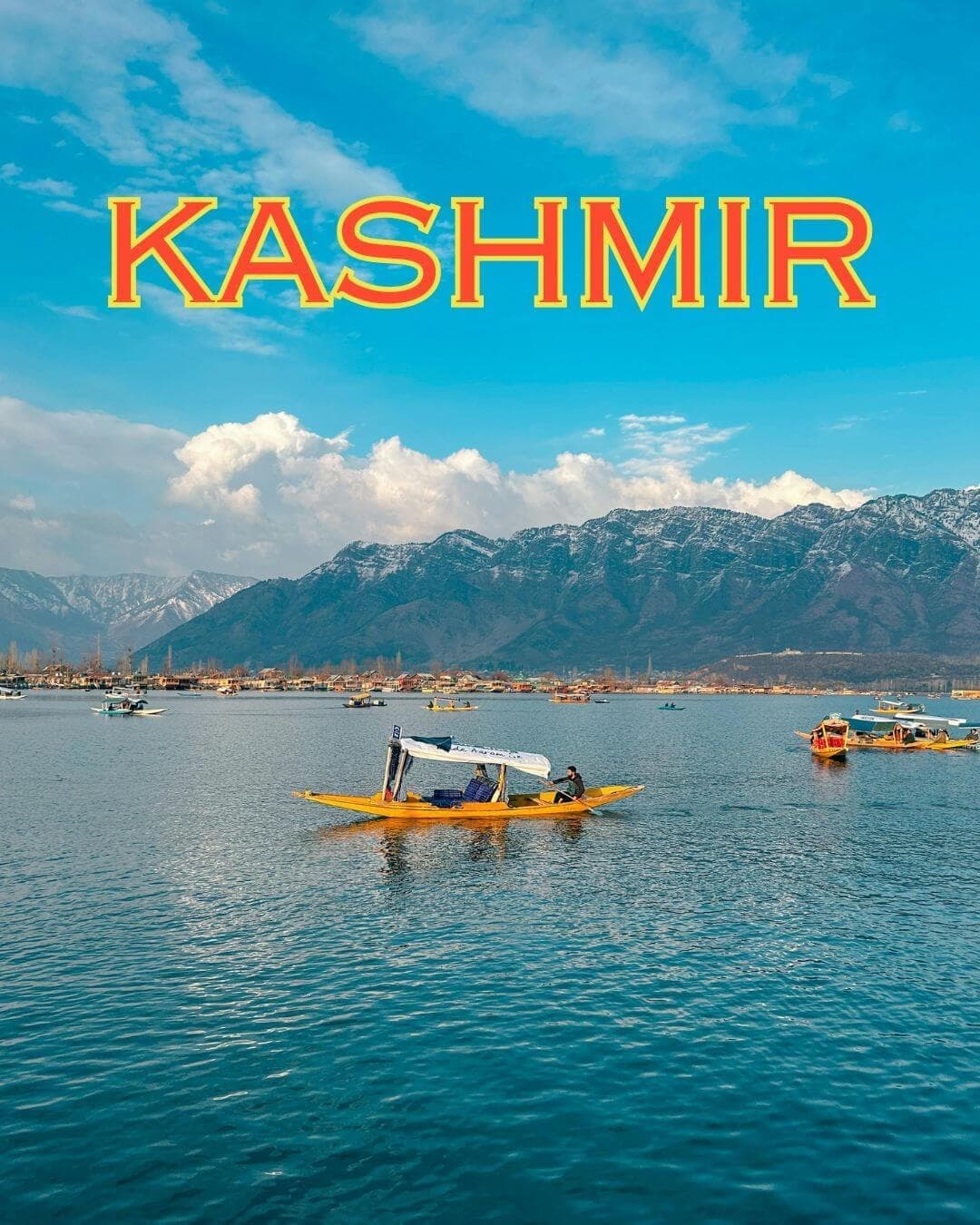 A shikara boat crossing Dal Lake in Srinagar, Kashmir, with the Himalayas behind