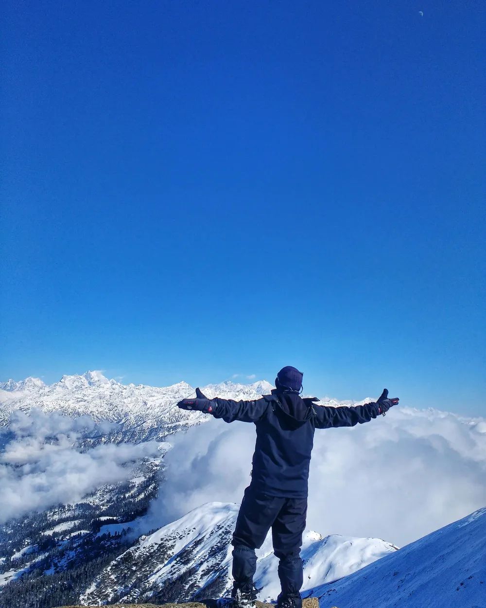 A TripoMusafir traveller celebrating above the clouds on a Himalayan summit