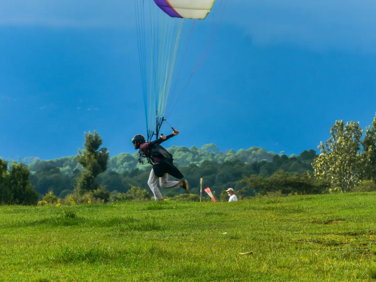A paraglider coming in to land in the open fields below Billing