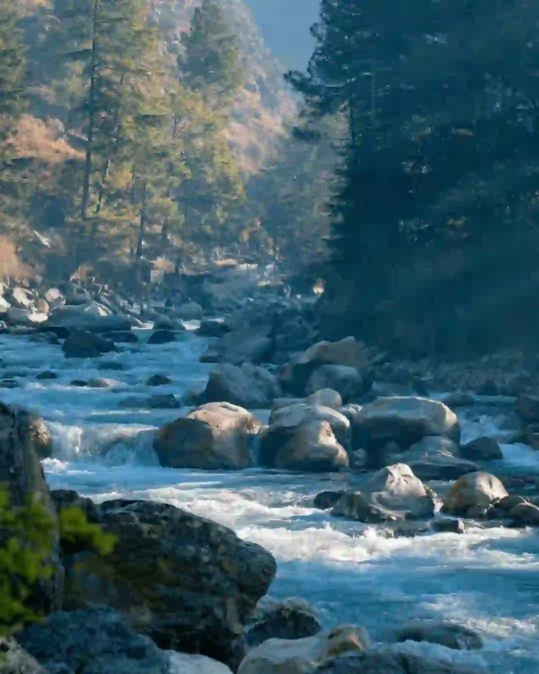 Hiker crossing a wooden bridge en route to Kheerganga