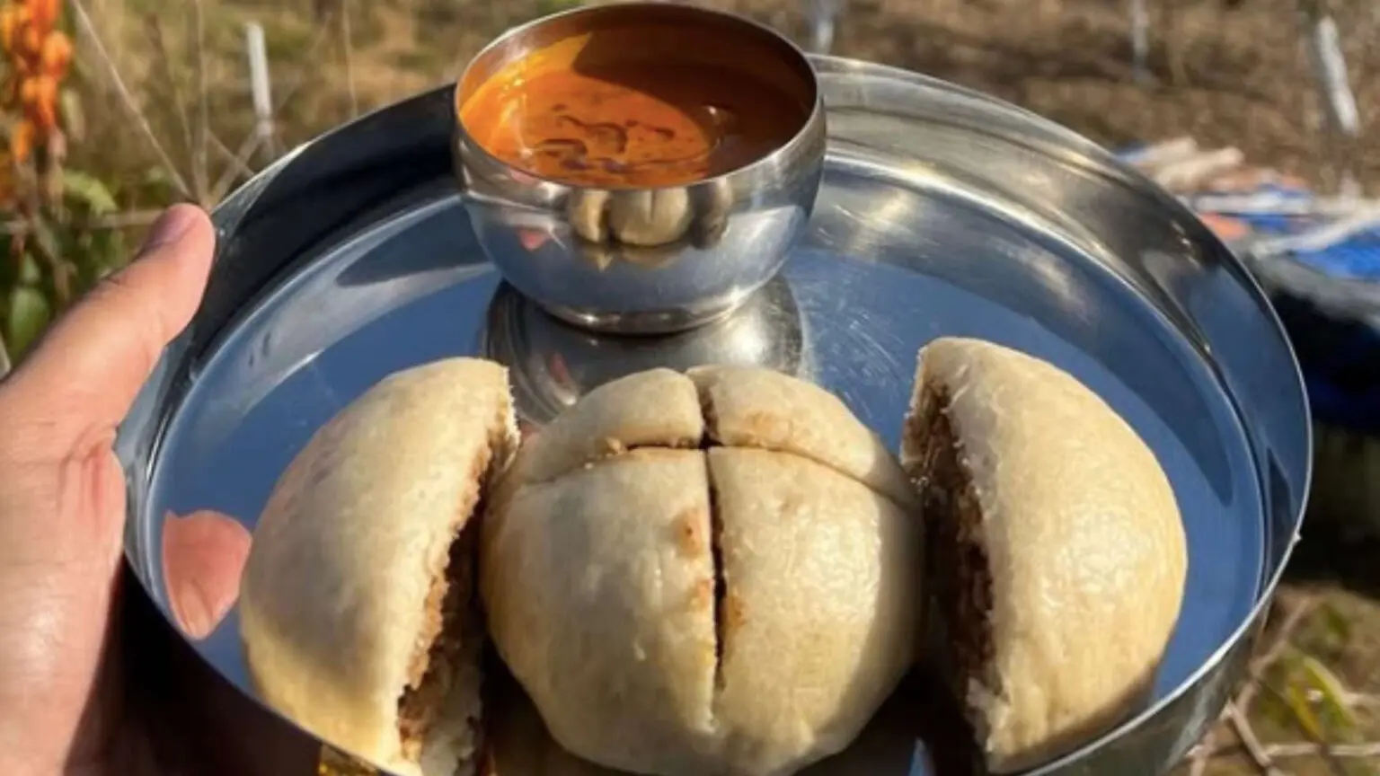 A plate of sidu, a traditional Himachali steamed bread, served with soup in Spiti