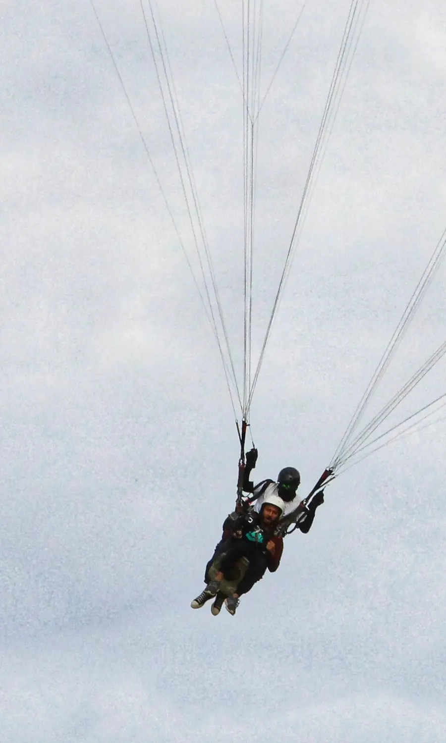 Tandem paragliding pilots mid-flight high above Billing