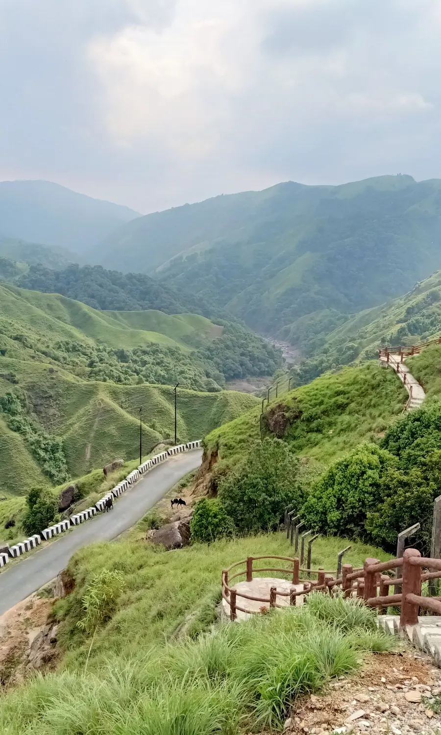 A viewpoint walkway winding along the green ridges of the Khasi Hills